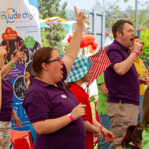 Small group of Include Choir members singing and signing at a summer fair