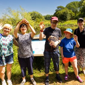 Stroll and Sign project participants smile and wave at the camera