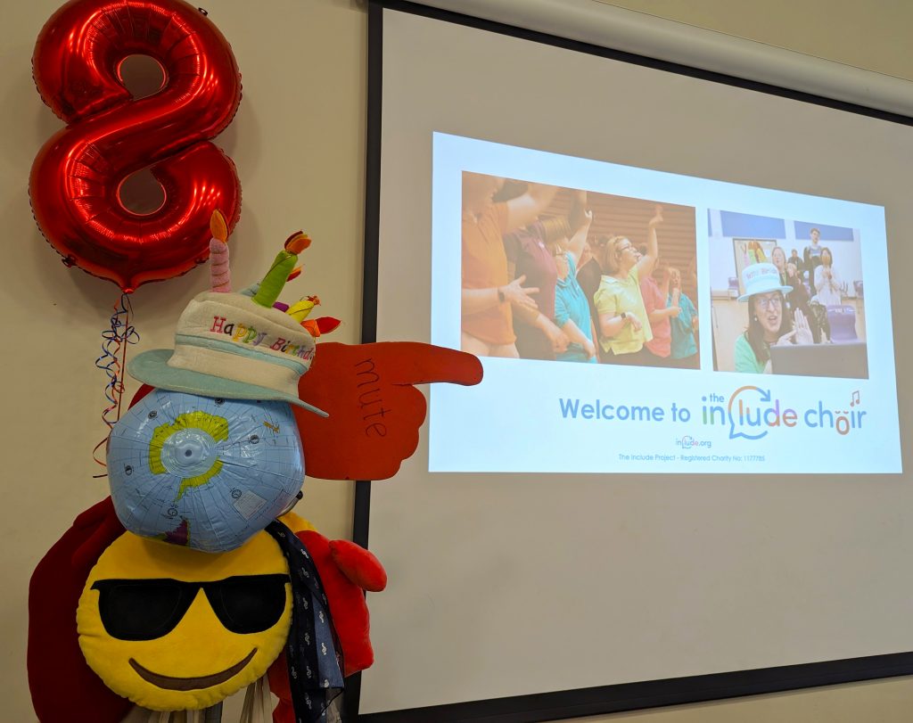 The Include Choir hatstand wearing a Happy Birthday hat next to an 8th Birthday baloon