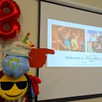 The Include Choir hatstand wearing a Happy Birthday hat next to an 8th Birthday baloon