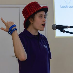 Amelia singing and signing into a microphone