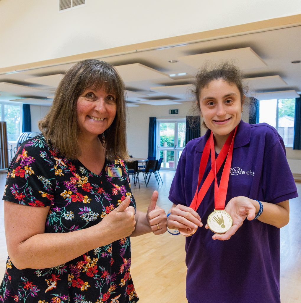 Amelia and Beth looking happy together as Ameila shows some medals she has won
