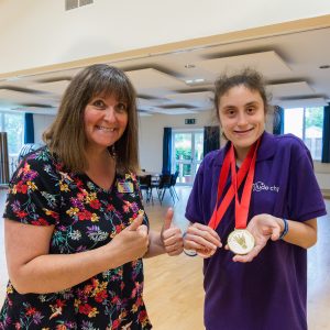 Amelia and Beth looking happy together as Ameila shows some medals she has won