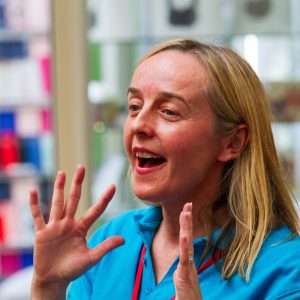 Include Choir Volunteer Charlotte sings with her hands held near to her face Makaton signing