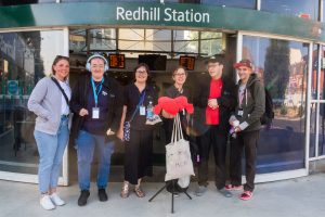 Members of the Include Choir standing outside Redhill Train Station