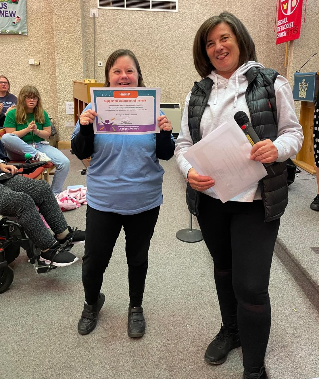 Include's volunteer coordinator Louise, with Include member Ellie holding a certificate