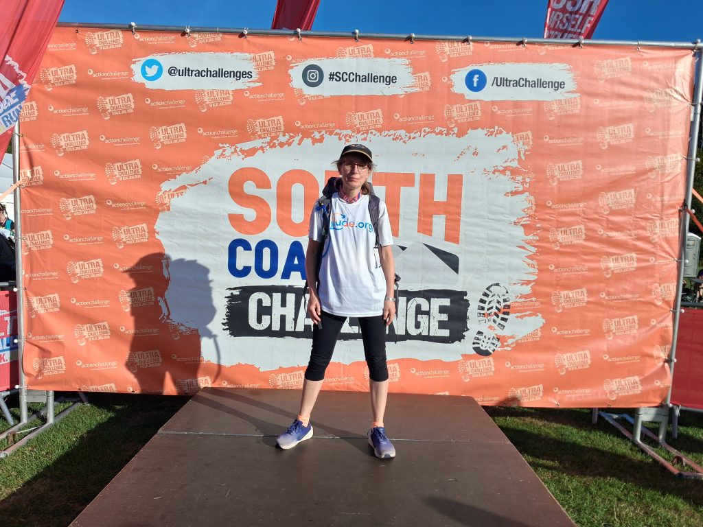 Alix standing infront of the South Coast Challenge sign